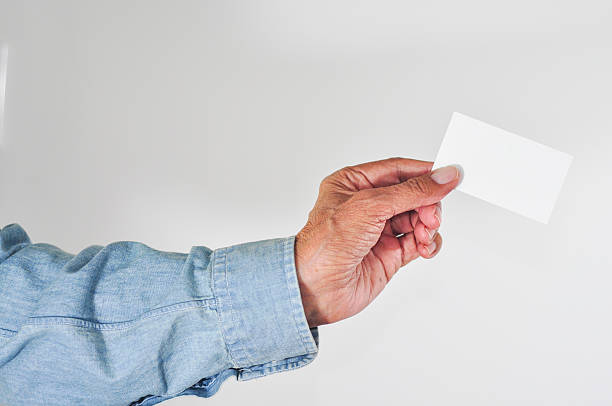 Senior man holding up a blank card. stock photo