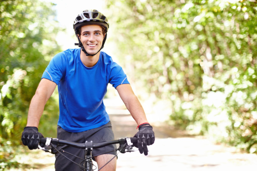 Portrait of a smiling man cycling in the countryside with copyspace