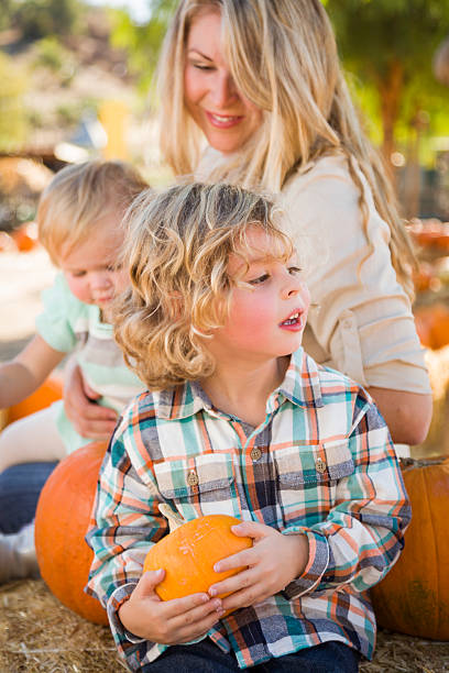 istock Attractive Family Enjoys a Fall Day at the Pumpkin Patch 186583291