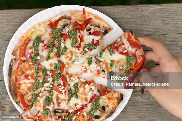 Рука Потянув Кусочком Вегетарианская Пицца С Соусом Песто — стоковые фотографии и другие картинки Бумажные тарелки