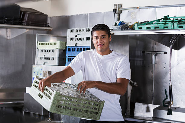 Restaurant worker in kitchen Hispanic man (20s) working as bus boy in restaurant kitchen. restaurant kitchen workers stock pictures, royalty-free photos & images