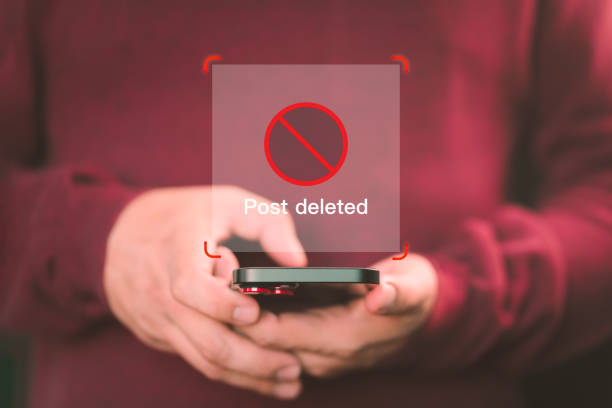 istock Young man using a mobile phone to play social media on a website, but the post has been deleted. Searching for more internet, search engine optimization. 1865870121
