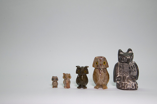 Collection of owls of different sizes carved in stone of different colors