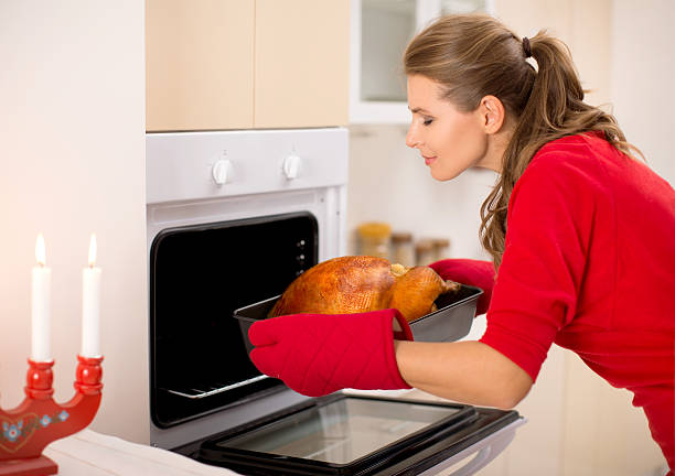 istock Woman preparing roasted turkey for dinner. 186590766