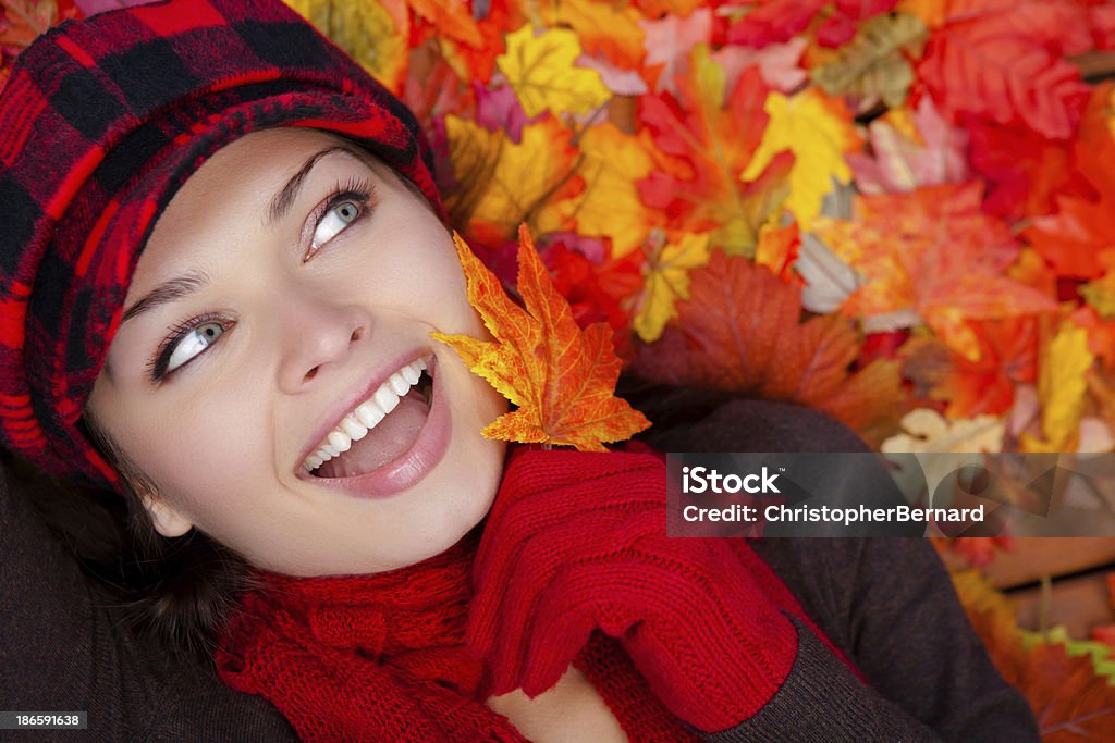 Felice giovane donna gettando autunno foglie su - Foto stock royalty-free di 20-24 anni