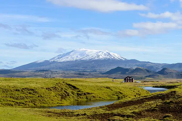 House in front of the Hekla volcano in Iceland.