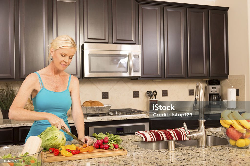 Comida: Mulher prepara a salada fresca em casa cozinha. - Foto de stock de 30 Anos royalty-free