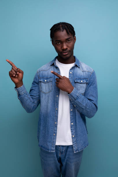 istock charismatic stylish african man with black dreadlocks points finger to the side 1865919320