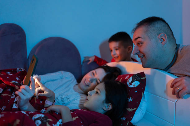 istock Happy family using smart phone at bedtime 1865929455