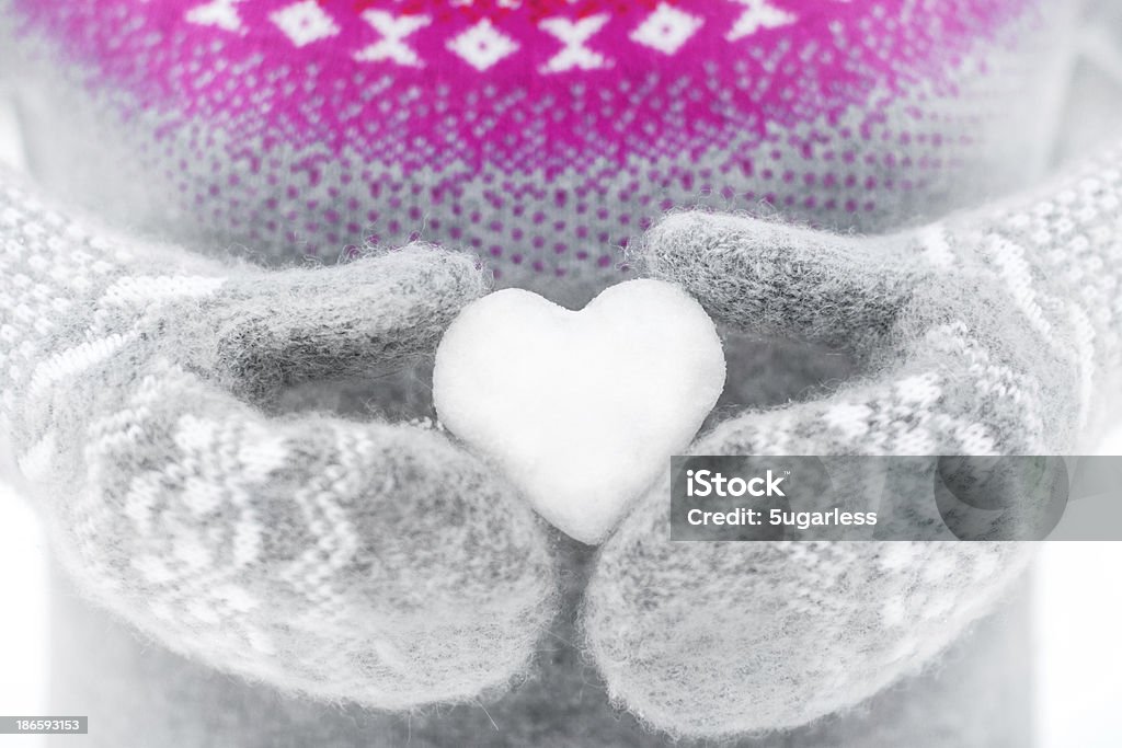 Holding heart-shaped snowball Snow Stock Photo