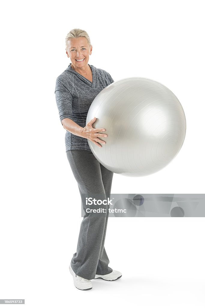 Senior mujer agarrando pelota de ejercicio - Foto de stock de Ejercicio físico libre de derechos