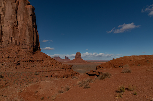 Wild west of tall spires and mesas of rich dark red rugged sandstone mountains near Monument Valley in Arizona and Utah of western USA in North America. This is part of the Navajo Native Indian Nation in USA.  Nearest cities are Phoenix and Grand Canyon Arizona, Salt Lake City, Utah, Denver and Durango, Colorado.