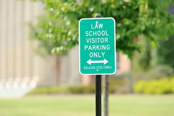 Sign in front of building law school visitor parking only violators cited or towed.