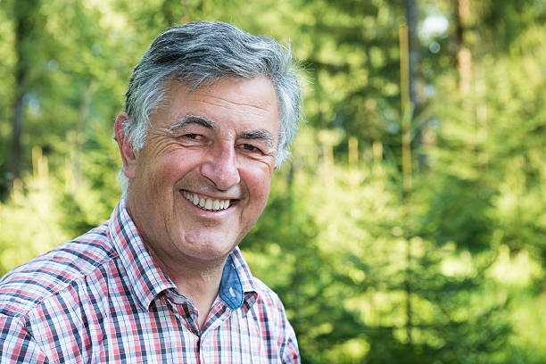 istock happy senior man smiling at camera 186594718
