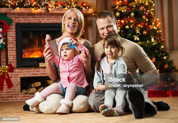 Happy Family On Christmas Eve Foto de stock y más banco de imágenes de Acontecimiento - Acontecimiento, Adulto, Adulto joven