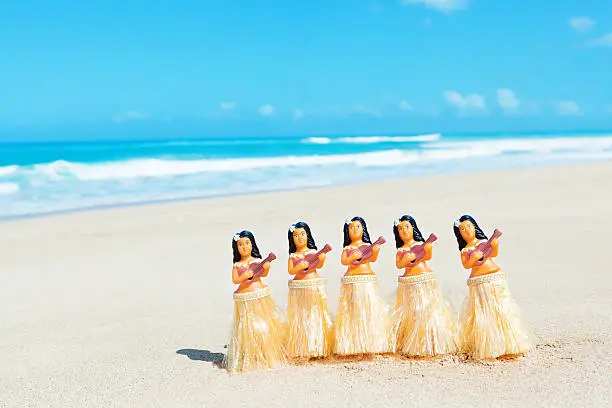 Subject: A group of hula dancer figurines on the Beach of Hawaii.
