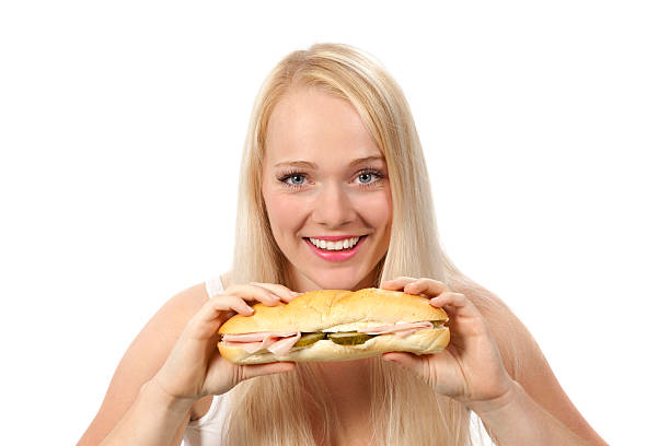 istock Young woman eating sandwich 186595791