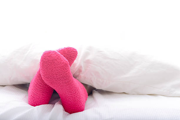 Woman relaxing in bed with pink socks