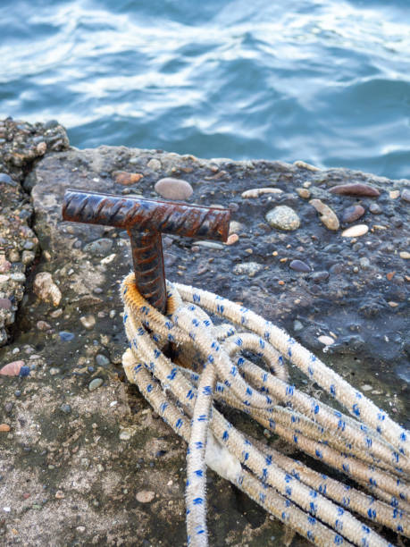 place for attaching a small boat. fittings for tying the mooring line. mounting point. small bollard on the pier. - moored nautical equipment circle rope - fotografias e filmes do acervo