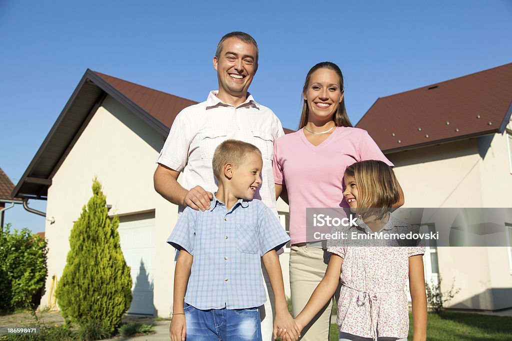 Famiglia con nuova casa - Foto stock royalty-free di Abbigliamento casual