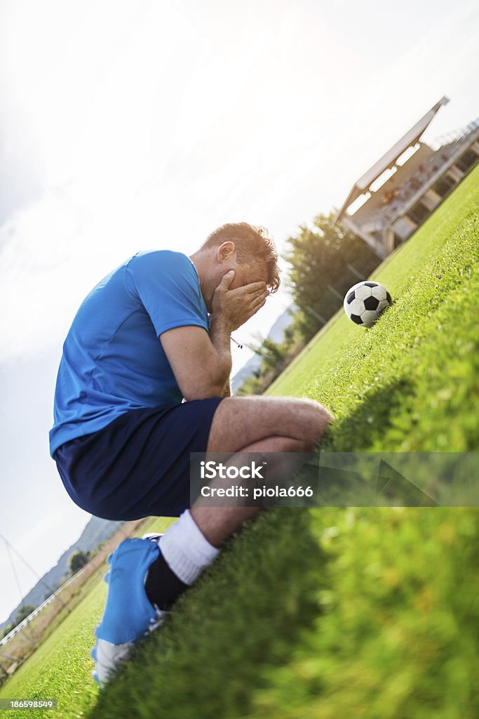 Desperate soccer player on the football pitch Loss Stock Photo