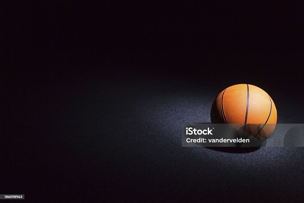 Basketball sur un sol foncé - Photo de Balle ou ballon libre de droits