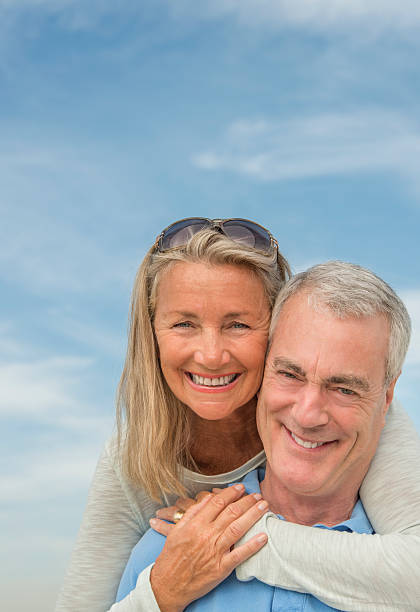 istock Man Piggybacking Woman Against Cloudy Sky 186598999
