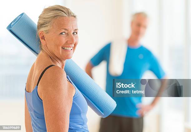 Smiling Woman With Exercise Mat At Home Stock Photo - Download Image Now - Exercise Mat, Active Seniors, Senior Adult