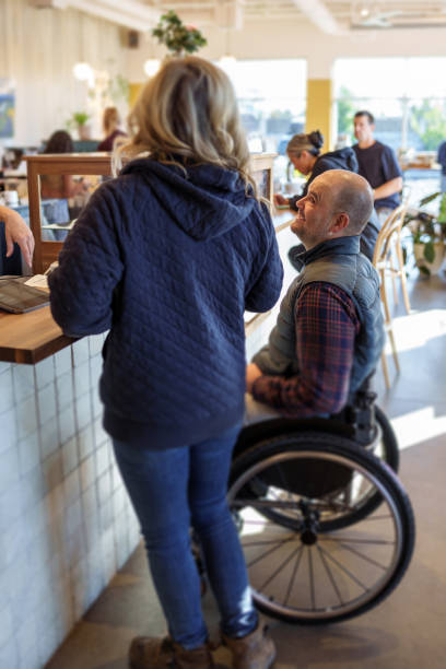 istock Man with a disability ordering food at a cafe with a friend 1866033301
