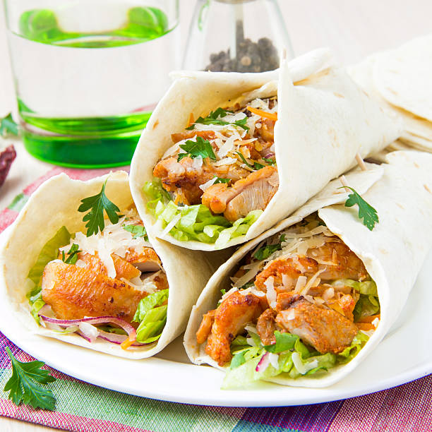 Wrapped in tortilla roll with fried chicken and vegetables stock photo