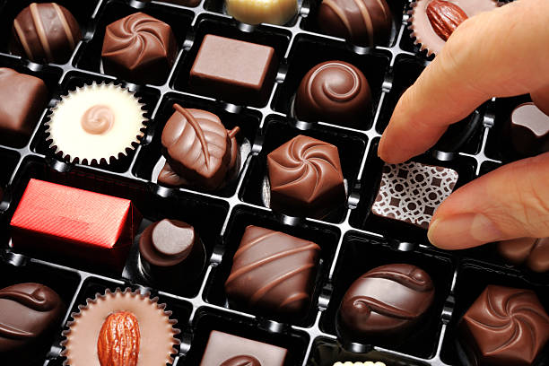 High angle view of choosing a chocolate from a box.