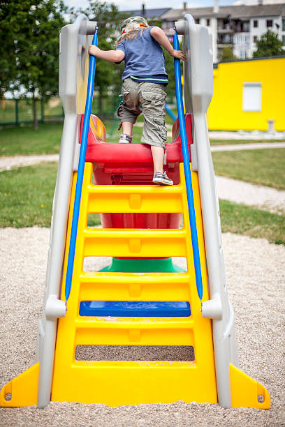 Little boy on the playground slide stock photo