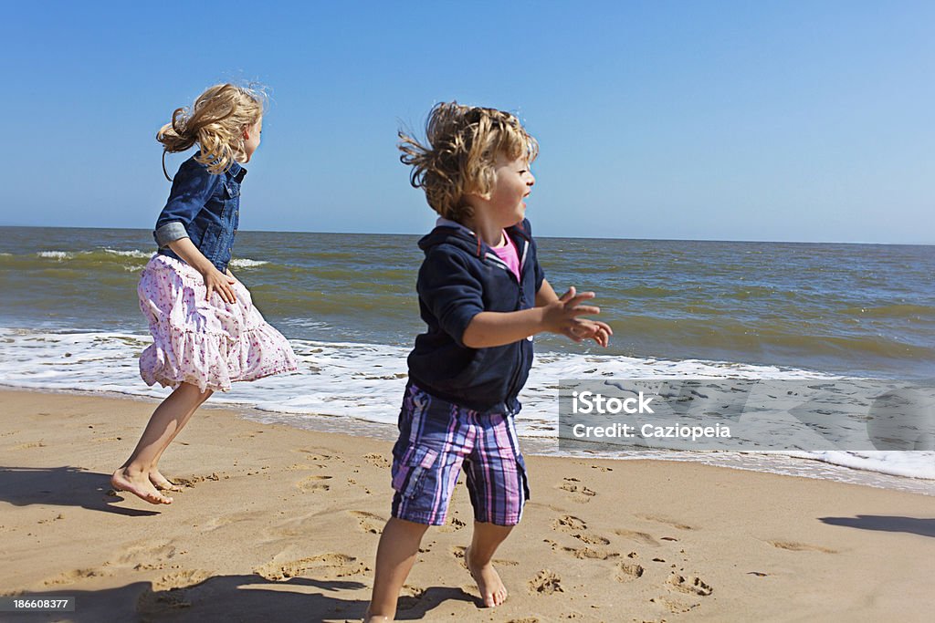 Duas crianças brincando na praia - Foto de stock de Família royalty-free