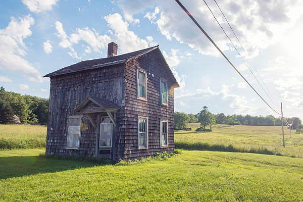 This is a horizontal color photograph of an old, abandoned wooden house in upstate New York.