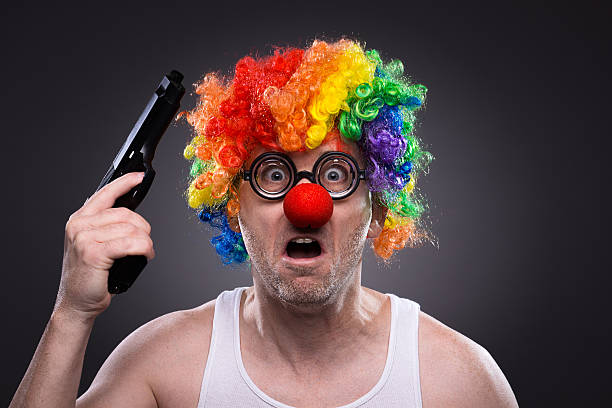 Angry man in a clown wig and nose, with gun