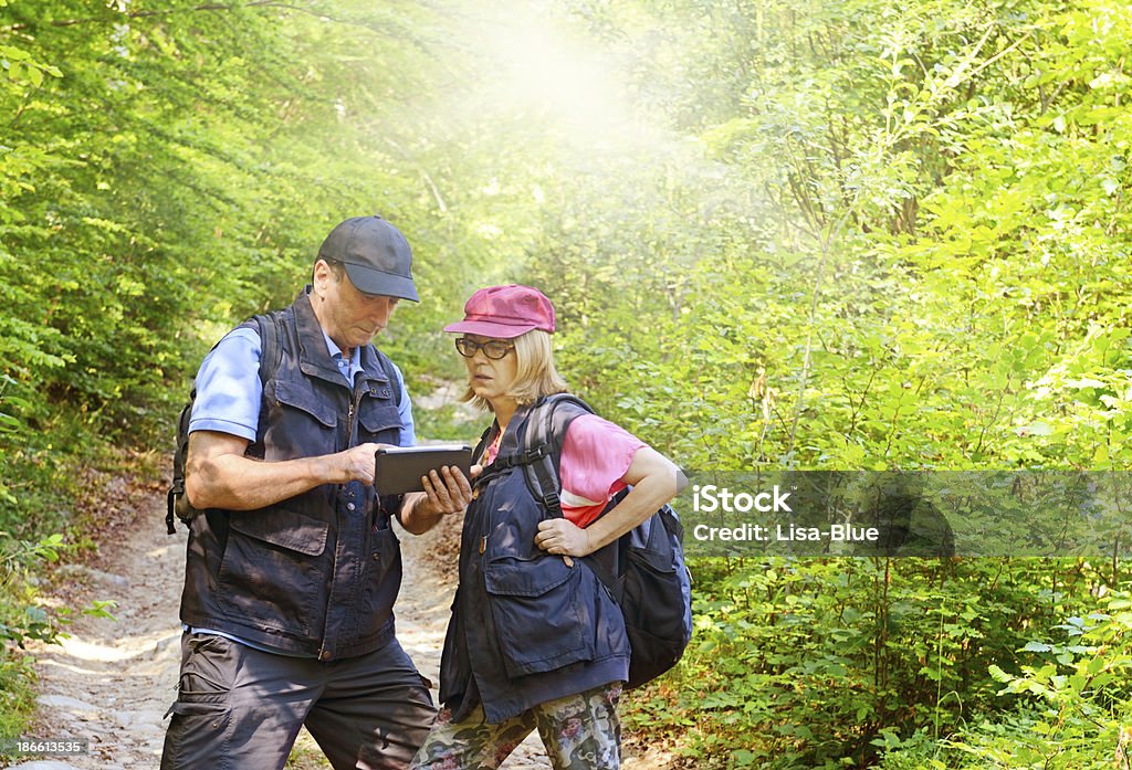 Casal maduro Tablet de leitura em uma floresta - Foto de stock de 50 Anos royalty-free