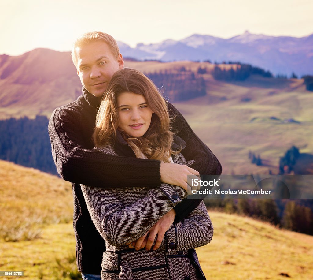 Romance in the Swiss Alps Young couple portrait embracing with the Swiss alps in the background. Focus on the woman. 20-29 Years Stock Photo