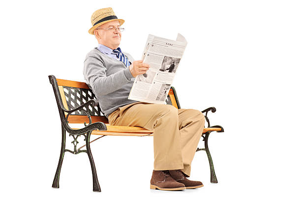 istock Senior gentleman reading newspaper and sitting on a bench 186614657