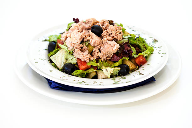Tuna salad with letuce, tomato and olives on a white background