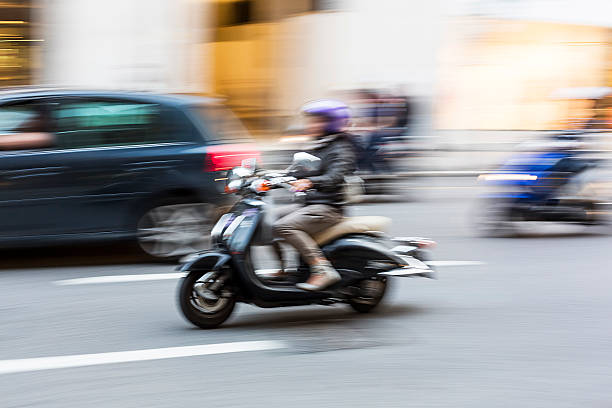 Woman using a scooter in the city .