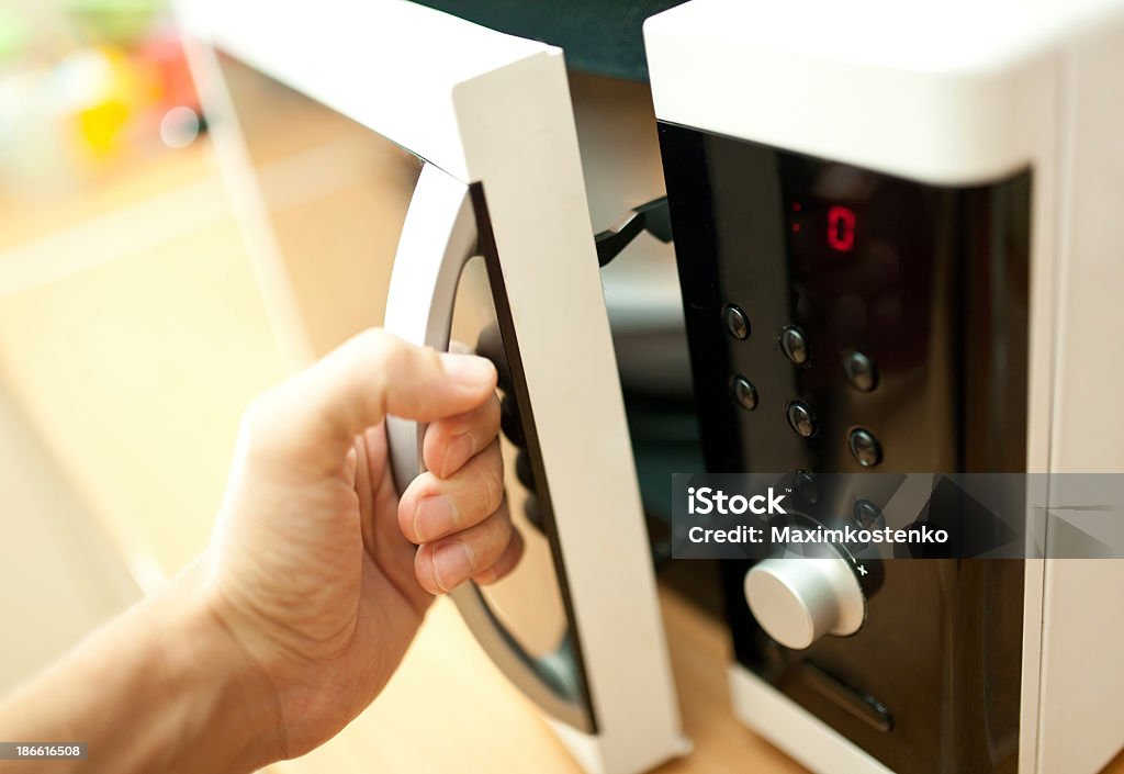 Hand of person opening a microwave oven Using microwave oven Appliance Stock Photo