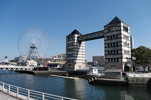 Large Ferris wheel and the Nipponmaru Memorial Park Tower Building in Minato Mirai, the central business district of Yokohama, overlooking Tokyo Bay, Japan.