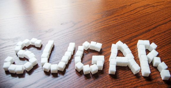 Sugar word in sugar cubes on wooden table