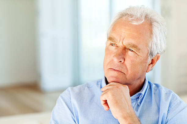 istock Senior Man Looking Away With Hand On Chin At Home 186617643