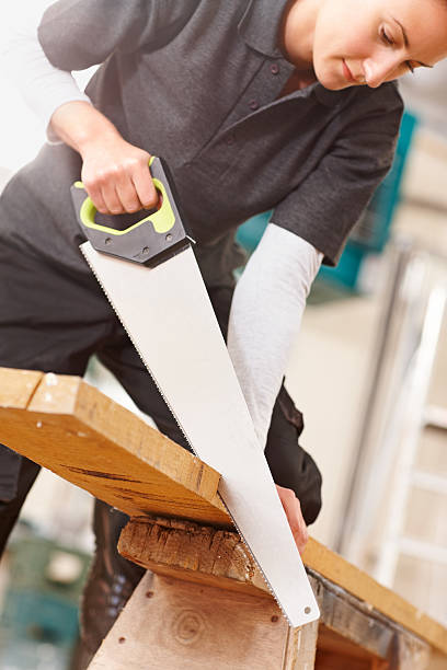 istock Female carpenter sawing wooden plank 186617784