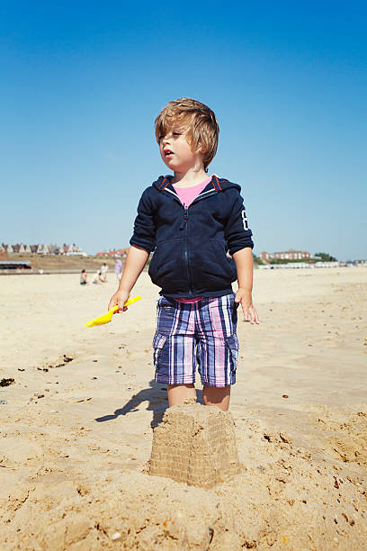 ragazzino gioca sulla spiaggia - sandcastle beach norfolk sand foto e immagini stock