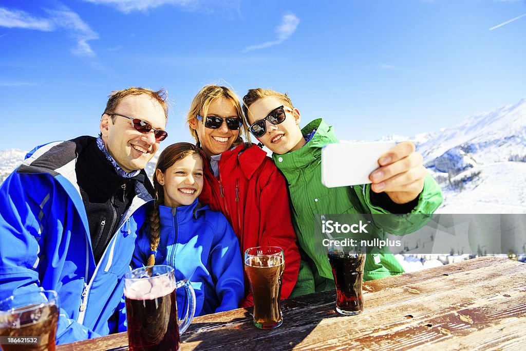 Familia de cuatro disfruta de una bebida en el área de los Alpes - Foto de stock de Familia libre de derechos