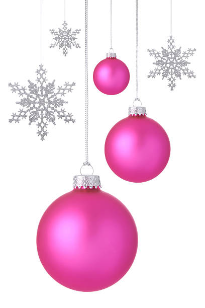 Pink Holiday ornaments with silver glitter snowflakes hangining on a white background.
