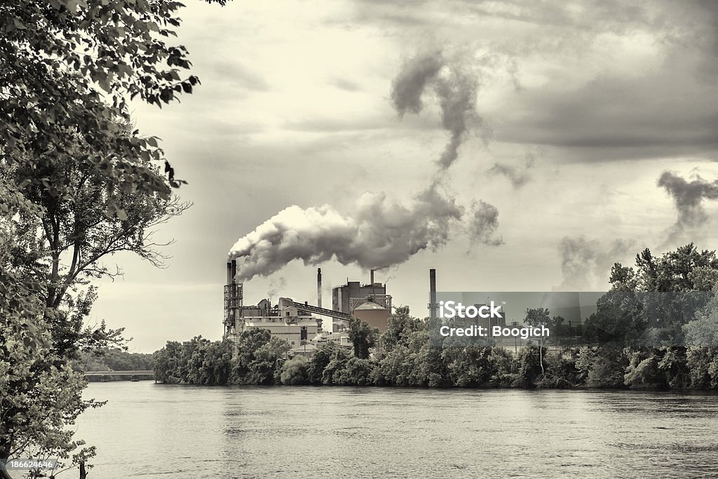 Factory Pollution This is a horizontal photograph of a factory billowing smoke into the air alone the Roanoke River. Roanoke Rapids - North Carolina Stock Photo