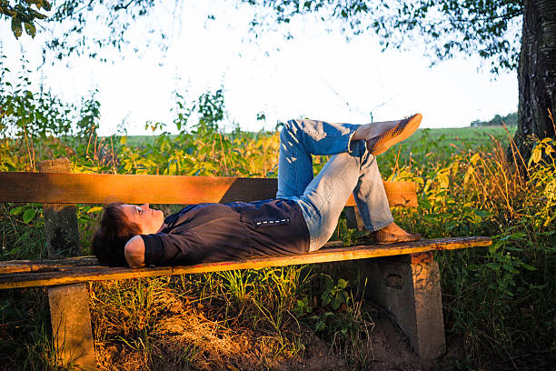 istock Woman lying on bench in sunset 186624746